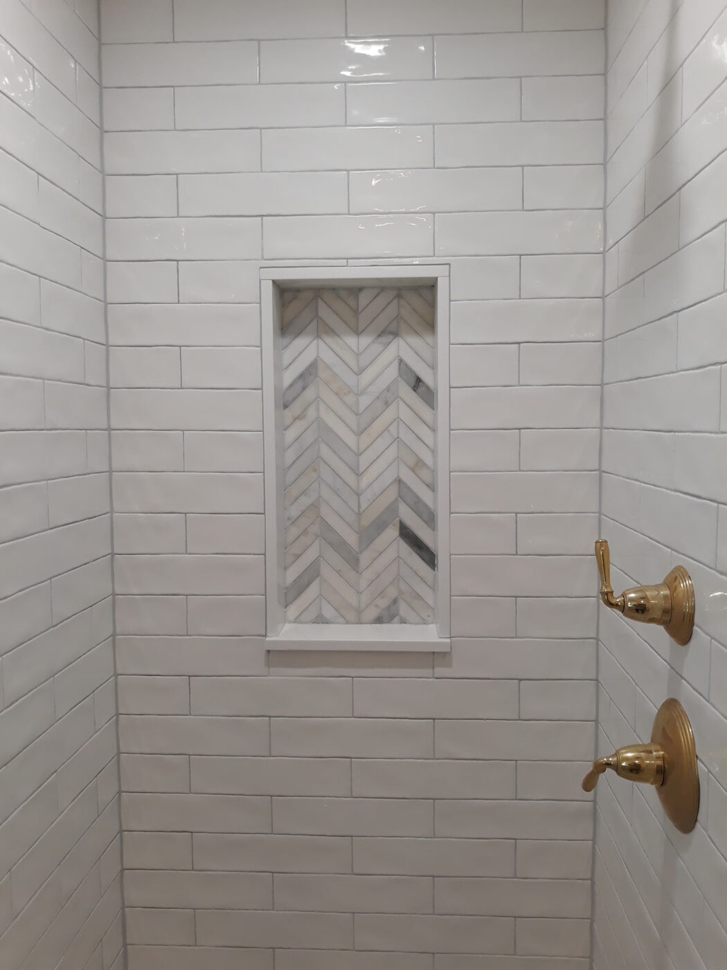 Subway Tile Shower with Herringbone Niche by Masterpiece Tile and Grout in the DFW area
